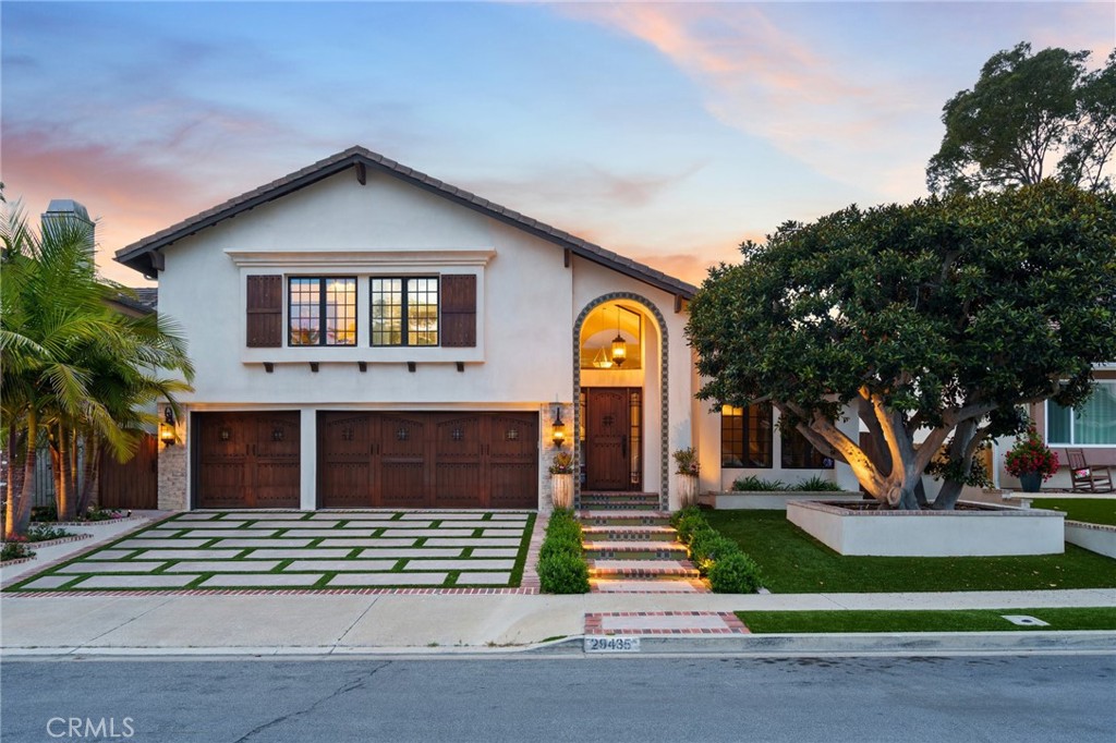 Welcome to this elegant and spacious 5 bedroom, 4 bath home in the highly coveted community of Kite Hill, Laguna Niguel. Showcasing sweeping views of rolling hills, mature trees, and lush landscaping, this beautifully upgraded residence blends timeless Spanish and Italian architectural elements with modern comforts. Step inside to discover distressed Brazilian hardwood flooring flowing throughout the main living areas, soaring vaulted ceilings, and oversized Milgard windows that flood the home with natural light. A striking dual-sided fireplace wrapped in marble tile adds warmth and sophistication, connecting the inviting living and formal dining areas. The dining room opens to the backyard through La Cantina bi-fold doors, creating a seamless indoor-outdoor entertaining experience. The chef’s kitchen features a new stainless steel 5-burner cooktop, double oven, new dishwasher, and generous counter space, all flowing into a versatile great room or family space—perfect for hosting gatherings or relaxing at home. Upstairs offers a rare and desirable 5-bedroom layout, highlighted by a luminous primary suite with bi-fold doors leading to an expansive private deck and trellis. The suite boasts sweeping tranquil views and a spa-inspired bathroom with dual vanities, a free-standing soaking tub, separate stone shower, and a walk-in closet. Step outside to a lush, resort-style backyard designed for both entertaining and peaceful relaxation. Enjoy the covered patio, built-in custom firepit, luxurious Arto and Granada tile, jacuzzi spa, and an impressive outdoor shower that lends a sophisticated coastal flair. The home’s exterior stuns with a custom driveway, rich wood garage doors, a bespoke Mesa front door and side gates, and smooth stucco under a tile roof. Additional features include a Kinetico water softener and reverse osmosis system, upgraded HVAC with dual-zone Nest thermostats, and exceptional curb appeal. Residents of Kite Hill enjoy resort-style amenities including a Jr. Olympic-size pool, tennis and basketball courts, sand volleyball, clubhouse, parks, and scenic trails. Newly remodeled YMCA with botanical garden and Laguna Niguel Regional Park just minutes away. With a low tax rate and no Mello Roos, this is a rare opportunity to own a beautifully appointed home in one of Laguna Niguel’s most desirable communities.