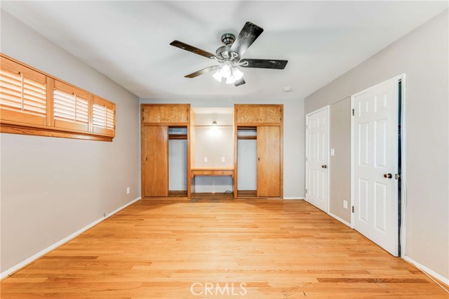 Primary Bedroom with built-ins and ceiling fan