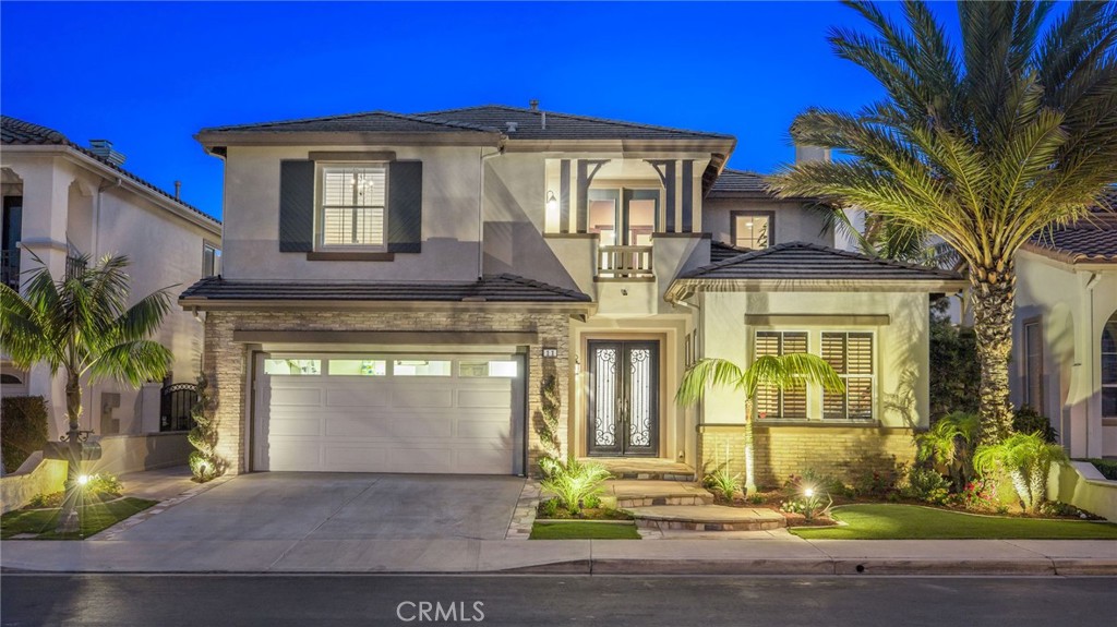 Step into refined luxury in the coveted gated enclave of Oak View Estates. This 5-bdrm, 4.5-bath estate-style home has meticulously curated living space, including 2 home offices, large upstairs loft w/ custom built-ins, and a show-stopping backyard oasis designed for elevated indoor/outdoor living. The grand double-door entry w/ custom wrought iron and glass opens to a large foyer, setting the tone with a dramatic spiral staircase, smooth-finish walls, and designer upgrades. The layout is as functional as it is beautiful, with 4 bdrms upstairs—including a luxurious primary suite—and a downstairs guest room with en suite bath. The open concept chef’s kitchen is a culinary dream, featuring a granite island, custom backsplash, Viking 5-burner cooktop with pot filler, vent hood, built-in refrigerator, wine refrigerator, recessed and pendant lighting, high-end stainless steel appliances, a walk-in pantry, and built-in desk area. The oversized family room is anchored by a stunning floor-to-ceiling stacked stone fireplace w/ custom built-ins, while the formal living and dining rooms offer space to entertain in style. Upstairs, you will find a generous loft, a private office with French doors, ceiling beams & built-in cabinetry. The expansive primary suite is a true retreat, offering access to a private upper deck of over 300 square ft—fully equipped w/ electrical, television, and separate stair access from the backyard. The remodeled primary bath includes a frameless glass shower, separate soaking tub and custom stone finishes. The walk-in closet has been extended and customized with a center island & designer cabinetry. The CROWN JEWEL is the backyard—featuring a saltwater pool & spa with Baja shelf & custom mosaic tile. A fully retractable slider creates seamless indoor/outdoor flow to the covered patio. A full outdoor kitchen showcases a FireMagic built-in grill, sink, refrigerator, vent hood, ice maker, and bar seating. Outdoor amenities include a fireplace w/ custom wood mantle, pristine lighting, surround sound, 2 fans, awning & 2 heat lamps. Artificial turf in both front back offers low-maintenance luxury. Additional upgrades include 2 finished attics w/ plywood flooring, fully owned solar w/ 38 panels, newly painted interior, new carpet, stone flooring, new upstairs windows, coated garage floor, upgraded moldings, baseboards, and casings throughout. Located minutes from world-class beaches in Laguna, Dana Point, and Newport.