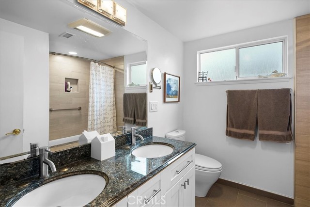 Main bathroom remodeled with granite counters and dual sink.