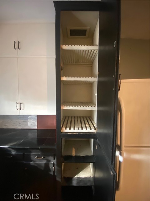 Unique shelving once was used to keep produce cool.  Refrigerator is up for discussion