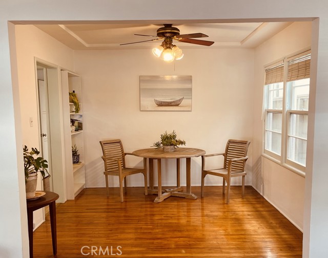 The dining area in one of the units has the same gorgeous hardwood floors, a ceiling fan and built-in bookcase. There is plenty of room for entertaining.