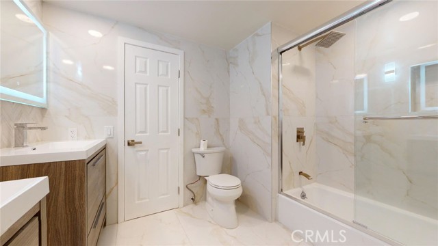 Large main hallway bath with two vanities and sinks and tub.