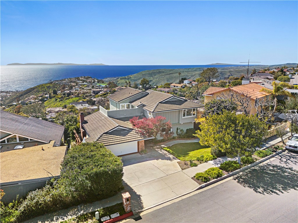 Ocean, Catalina Island and coastline views. Rare, two-level home on the ocean view side of Alta Laguna Blvd, this 4 bedroom and 3 bath home presents wonderful interior and exterior spaces from a 8,000+sf view parcel. The main level includes a formal living room w/fireplace, family room & dining, an unique circular kitchen w/stainless appliances, an oversized guest room w/kitchenette & separate entrance, a 3/4 bath & under-roof access to the 2-car garage. A massive ocean view entertainment deck w/hot tub serves all the major rooms from the main level. The upper level boasts an expanded primary suite w/upgraded bathroom, sitting areas, a private deck and an office nook. Panoramic views are stunning from this primary bedroom. Also on this level there are two additional bedrooms & a full bath. Recessed lighting, solid oak & terracotta flooring and a gracious floor plan complement the warm feeling inside. Outside, the street side presents a large lawn accented w/specimen trees. Because of the elevation and projection of the house, the oceanside of the home provides unobstructed views from the aforementioned deck as well as a lower yard with garden & sitting elements. A Large storage room is found under the deck that also provides for future expansion. Very close are the middle and elementary schools, Alta Laguna Park with playgrounds, tennis/pickle ball as well as access into the vast Aliso and Wood Canyon Preserve. The beach, shops and restaurants are a 5 minute drive. Come for a visit and stay for a Catalina Island sunset.