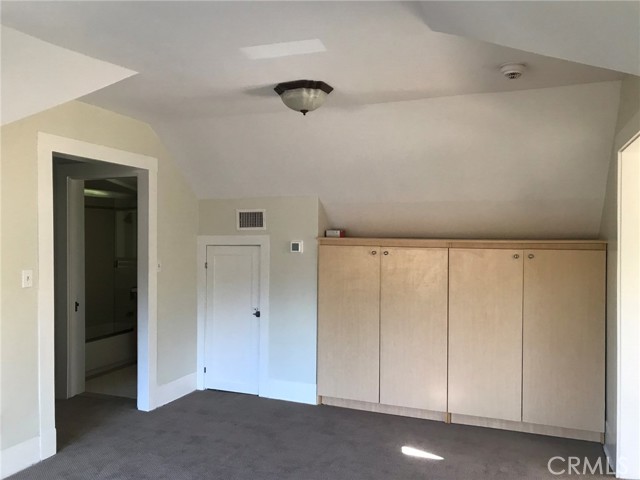 Stair case leads to this room in the middle of the attic unit.  Door on left leads to short hallway with full bath and kitchen.