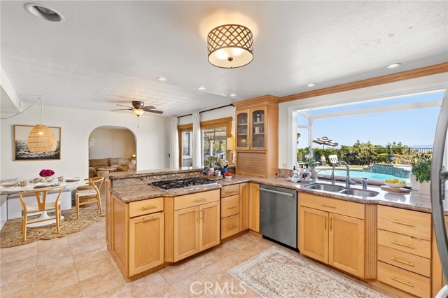 Bright eat-in kitchen, featuring stainless steel appliances and custom cabinets, flows seamlessly into the formal dining room and  family room.