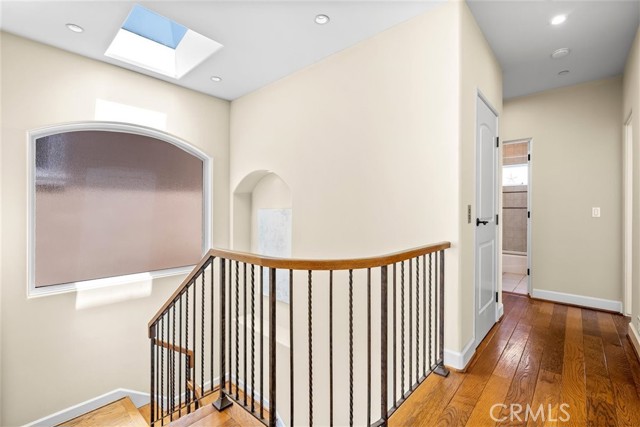 Hallway on top level leads to extra bedroom, laundry room, additional bathroom and storage