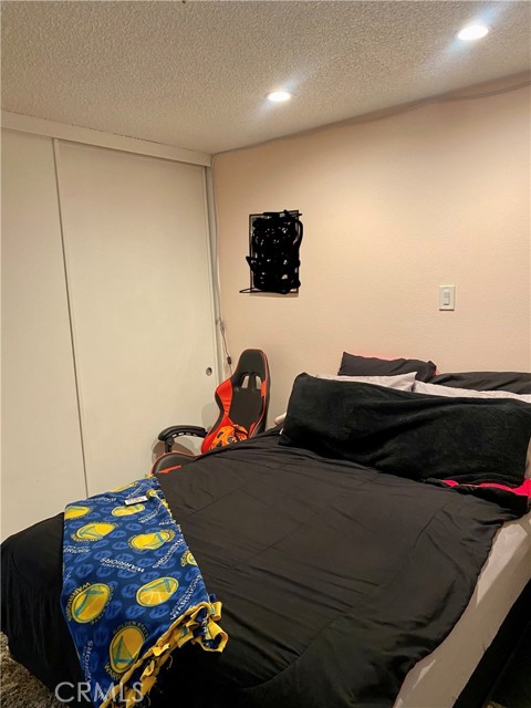 Another view of bedroom 2 with closet, recessed lights and shutters.