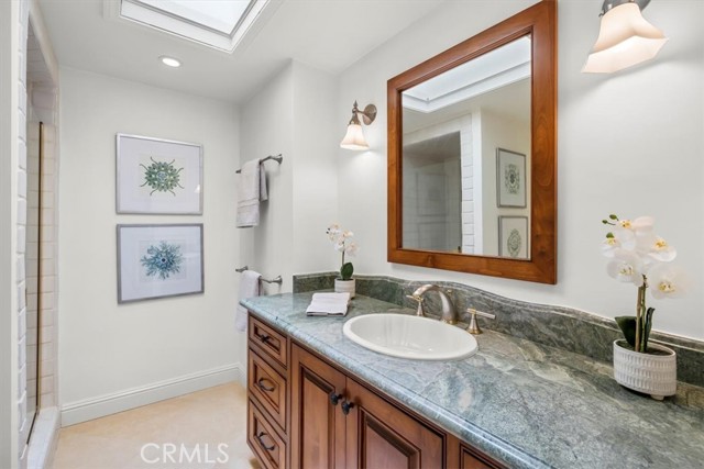 Hall Bathroom with Skylight, Updated Shower, Stone Counters and Marble Floors.  This services two Bedrooms opposite this bathroom.