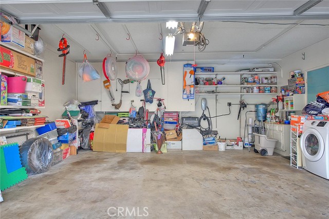 Double Car Garage With Tons Of Shelving & Overhead Hooks.  Huge Cabinet At Far End Of Wall