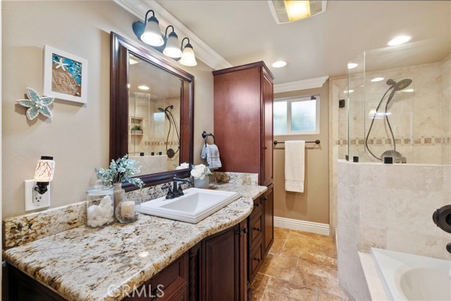 Although this bathroom is larger than the primary, it features a separate walk-in shower with bench and a jetted tub. Granite counters and lots of storage.