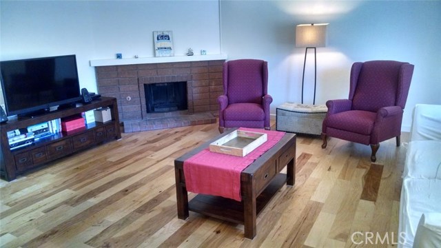 Living room with corner fireplace and sliders to front patio.