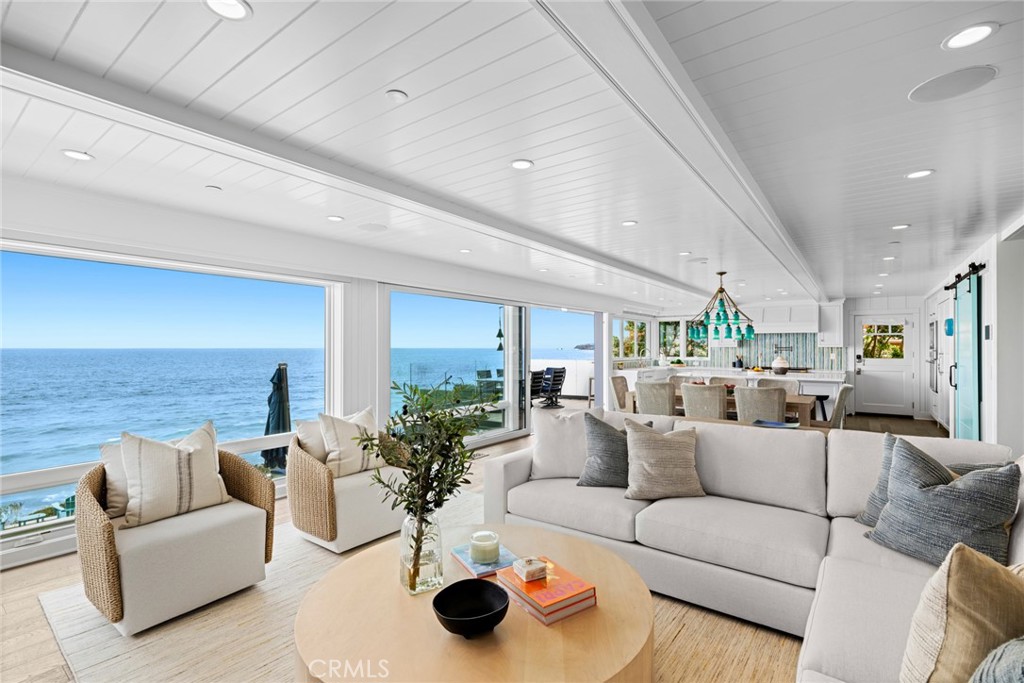 Experience the pinnacle of coastal elegance in this phenomenal oceanfront home that overlooks breaking waves, Catalina Island, north coast city lights and the azure Pacific from its extra-wide site in the heart of Laguna Beach’s thriving village. This newly updated home was originally built in 2013 and offers unobstructed ocean views that elevate your lifestyle, all just a short stroll from vibrant restaurants, shops and galleries. The expansive design features four bedrooms with most offering ensuite baths, an office, cabana and five baths in approximately 3,181 square feet. Floor-to-ceiling windows bring breathtaking ocean views and natural light into the main level, which opens to a spacious heated deck and a flat yard with spa. Enjoy the rewards of a temperature-controlled 250-bottle wine room, a generous walk-in pantry with sliding barn door, and access to a side-yard vegetable garden for farm-to-table freshness. An impressive suite of top-of-the-line appliances from Thermador, Miele and U-line includes a 6-burner range with pot-filler, a cabinet-matched built-in refrigerator, two dishwashers, and two under-cabinet wine refrigerators. Living areas offer premium millwork, including beamed ceilings, and tongue-and-groove ceilings, all of which adorn a floor plan that is incredibly functional. Every level opens to glorious ocean views, including a lanai that hosts a fabulous media lounge with ensuite bath, its own laundry, and a secondary kitchen equipped with a wine refrigerator and ice maker. The lanai opens to the backyard patio with stunning ocean views and a high-end built-in grill with side burner. The solar-powered home is further distinguished by an opulent primary suite with walls of glass that frame priceless views of the ocean. Two closets are featured in the suite, and its spa-style bath offers the luxury of heated flooring. High-end coastal style belies the home’s cutting-edge tech, which works behind the scenes to provide comfort, convenience and efficiency. A state-of-the-art Savant smart-home system incorporates wall-mounted iPads that can program and operate a top-tier audio/video system, security cameras, new automated blackout shades & more. The residence’s enviable location is moments from Laguna’s desirable HIP District, award-winning Laguna Beach schools, and a wide world of recreation, including hiking trails, surf breaks, and scenic blufftop parks. Live the lifestyle you have always desired & make this unparalleled home yours.