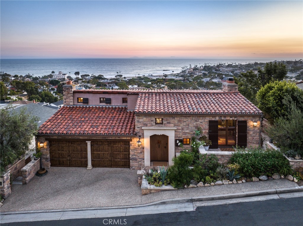 Stunning... serene... simply spectacular! Brought to life by acclaimed architectural designer John O’Neill in 2005, with no expense spared, this authentic Tuscan revival home is an engineering and architectural marvel. It offers the rare combination of impeccable design and one of the finest front-row ocean views available in Laguna Beach. Every room has expansive stand-up and sit-down Main Beach whitewater views. Three large tiled terraces allow unobstructed 270-degree panoramic coastline viewing. Its ideal location in lower Mystic Hills provides access within minutes to town and the tranquil sound of breaking waves and the village church bells. At night, settle in and relax to the magical twinkling city lights. Inside the home, the beauty is in the timeless details and meticulously selected materials. The property features: solid walnut flooring and alder doors throughout, antique light fixtures sourced from Europe and wired to modern standards, high ceilings with hand-hewn solid wood beams, Newport Brass fixtures, Italian double-pane Albertini French doors, 3 fireplaces framed by hand-carved Texas limestone, and so much more! The chef's kitchen features: furniture quality walnut custom cabinetry, honed marble counters and farmhouse sink, SubZero concealed refrigeration with 4 refrigerator drawers and 2 freezer drawers, SubZero 75 bottle wine cooler, Bosch concealed dishwasher, and Viking six burner range and hood surrounded by a hand-carved limestone hearth. With its zoned HVAC, central vacuum, new Rinnai high-capacity tankless water heater, built-in sound and security, and water efficient irrigation, this home is not only beautiful but also state of the art. Drought tolerant authentic Mediterranean landscaping complements the elegant stone and stucco exterior of this ultra luxe estate. Walking distance to sunny CA beaches, world class dining, and shopping in downtown Laguna Beach. For those seeking uncompromising style and design, this is THE hillside villa you've been waiting to call home! Additional upgrades/features list in supplements.