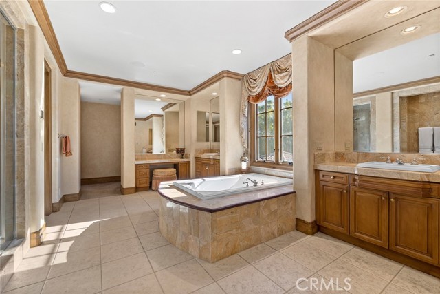 Primary Bathroom with separate sinks, vanity, separate toilets and bidet, shower with multiple shower heads, soaking tub