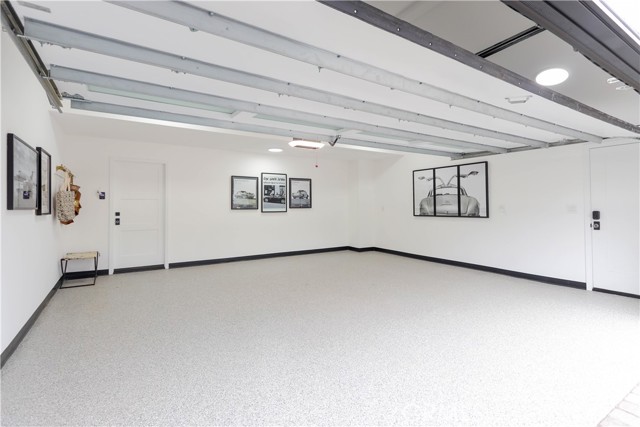 The immaculate garage with pristine epoxy floors and a polished finish offers both functionality and presentation for car enthusiasts. Plus direct entry to the walk-in pantry with drop station and built-in beverage cooler.