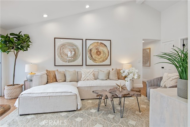 Family room off kitchen with hardwood floor and 2 skylights open to side patio