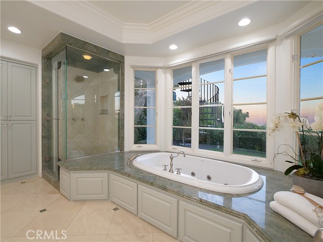 Walk-in shower and large jacuzzi tub with sunset views