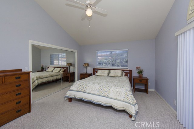 Master bedroom with high ceiling and ceiling fan.