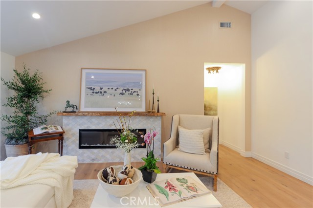 The living room fireplace is an inviting focal point for relaxing and entertaining. Unique tile and raw-edge, reclaimed wood mantle add character.