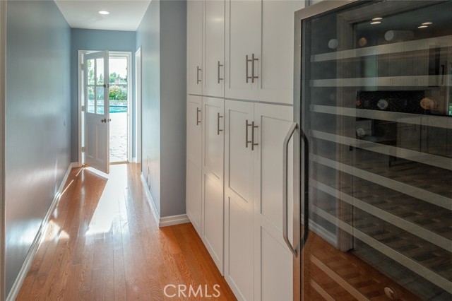 Pantry area off of kitchen with wine fridge with bathroom for the pool at the end of the hallway