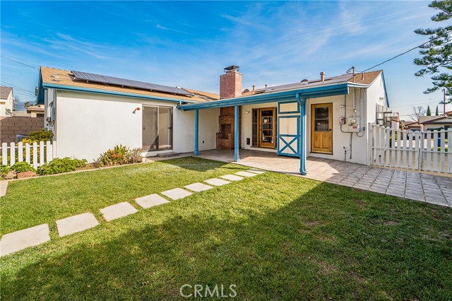 Grassy backyard with separate garden area, wood storage and detached two car garage.