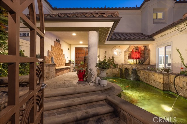 The entry courtyard enchants with custom fountains, a koi pond, and double entry doors.