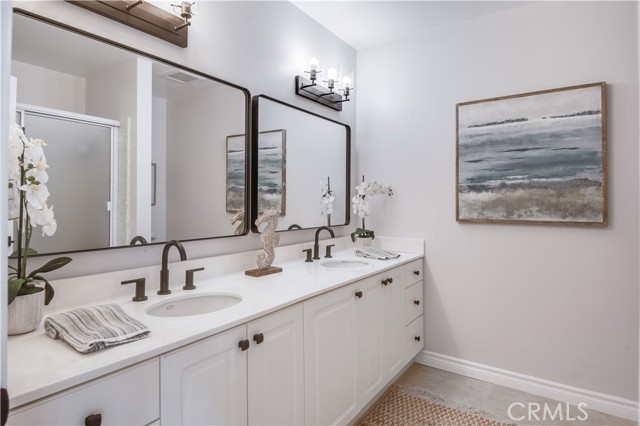 Full hall bath with two sinks, bathtub shower combination.