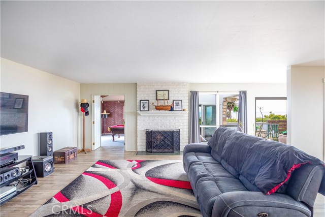 Large living room with fireplace opening to game room