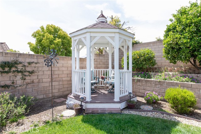 The backyard gazebo is a peaceful place to see the beautiful flowers and landscaping in the corner of the backyard.