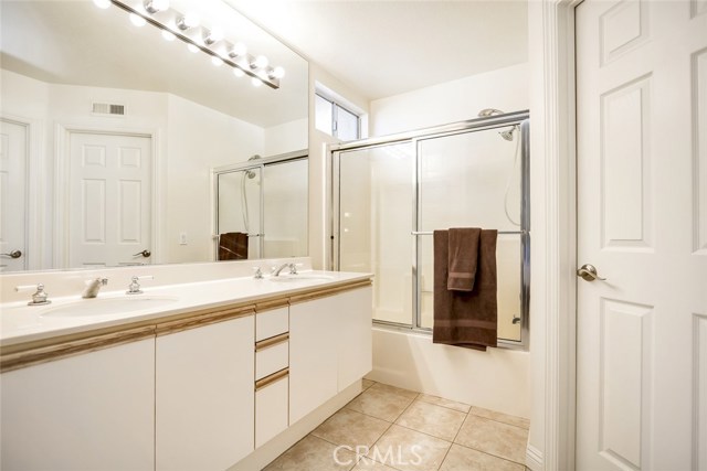 Master bathroom with dual sinks and walk in closet