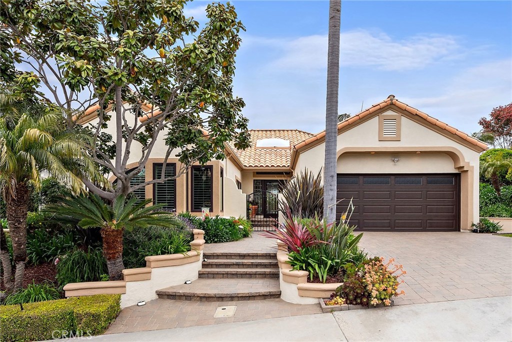 Tucked behind the private gates of Monarch Beach, 13 Tirremia blends timeless elegance with relaxed coastal living in one of Dana Point’s most coveted communities. Single-story ease, abundant natural light, and soaring ceilings create an open, inviting atmosphere throughout the home. Energy-efficient solar panels further enhance the home’s functionality and value.
The formal living room welcomes you with a warm fireplace, and dual French doors open to a beautifully manicured backyard — a tranquil extension of the interior living space. The formal dining room also opens outdoors, offering seamless flow for both intimate dinners and lively gatherings.
The kitchen is thoughtfully designed with an abundance of cabinetry, built-in range, wine refrigerator, and a convenient built-in desk — ideal for working from home. A spacious family room with a second fireplace connects effortlessly to the kitchen, creating the perfect hub for everyday living and entertaining.
Two secondary bedrooms with custom plantation shutters share a completely updated Jack and Jill bathroom featuring dual vanities, sleek cabinetry, and a modern walk-in shower. An additional powder room adds flexibility and ease for guests.
Privately set apart, the primary suite is a peaceful sanctuary with direct access to the backyard oasis. The spa-inspired primary bath offers a freestanding soaking tub beneath a striking chandelier, a large custom-tiled walk-in shower with dual shower heads, and dual vanities — all curated with luxurious finishes to create a calming, retreat-like feel.
The outdoor space is equally impressive: a sparkling pool and spa, built-in BBQ, outdoor woodfired brick oven, and a cozy outdoor fireplace set the stage for year-round entertaining or relaxing evenings under the stars. Lush landscaping enhances the sense of privacy and serenity.
Residents of Monarch Beach Villas II enjoy access to beautifully maintained parks and a dedicated dog park, all within the gates of the community. Beyond the neighborhood, you're just minutes from the sandy shores of Salt Creek Beach and Strand Beach, the world-renowned Ritz-Carlton and Waldorf Astoria resorts, and the vibrant shops and restaurants of the Lantern District.
Elegant yet comfortable, 13 Tirremia captures the very best of coastal luxury living.