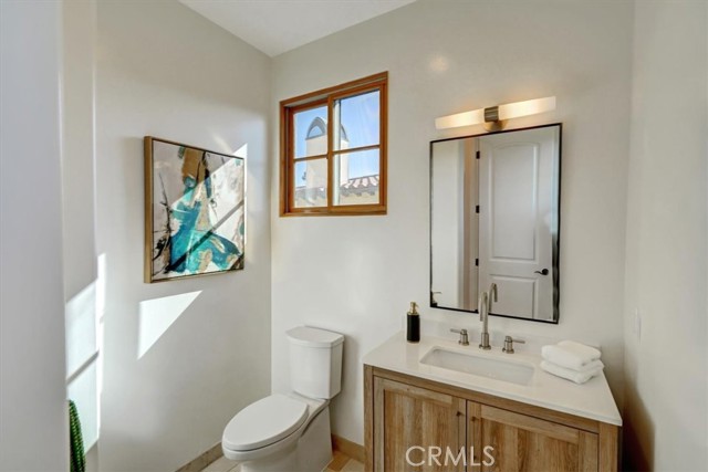 Powder room with new vanity, mirror, lighting and plumbing fixtures and toilet