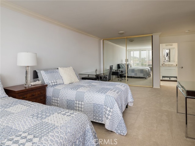 There are two sets  of mirrored double closet doors in primary bedroom suite (one off camera to the right), view to primary bathroom.