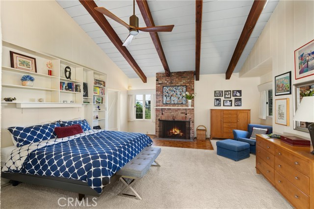 The primary bedroom has open beam ceilings, a fireplace and built in bookcases.