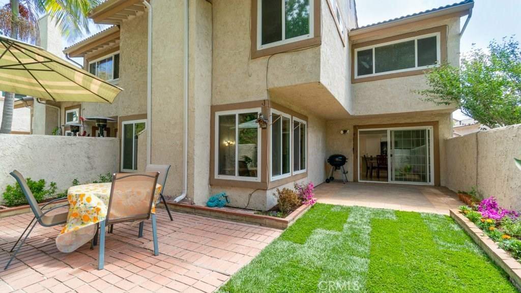 Spacious end unit townhome w/over 1800 sq. ft. of living space.  Gated courtyard entry leads you to this well-appointed home w/formal entry, large living room w/wood flooring, re-textured ceilings, cozy FP & lots of windows.  Separate dining room which is open to the kitchen & has wall length sliding door which leads to the large wrap around back yard.  One of the best locations in the community w/beautiful view of greenbelt/hills.  Big kitchen w/breakfast nook for casual dining & direct access to the 2 car garage w/roll-up garage door.  Updated kitchen features all white cabinets, Calcutta Laza quartz counter tops, stainless steel sink, brushed nickel faucet, near new stainless steel gas range & microwave, recessed lighting & a long breakfast bar perfect for family gatherings & entertaining.  The two secondary bdrms are set apart for privacy.  Updated second bath.  Linen cabinets for ample storage.  Huge mstr bdrm w/double door entry, vaulted ceilings, FP, walk-in closet & ensuite bath.  Vinyl plank flooring & framed vanity mirror dress up the master bath.   Freshly painted t/o in a trendy light beige.   Newer dual pane windows/slider.  HOA inc. water/trash, structure insurance, some ext. maintenance, common area landscaping, lighted tennis court, clubhouse, BBQ area & new roofs 2018.  Minutes to the beach, Downtown HB & Bella Terra w/great shopping & dining.  Close to 405 FRWY. 1¼ miles to Lake View ES, 2.93 miles to Vista View MS, & 2.7 miles to Ocean View HS.  A must see!