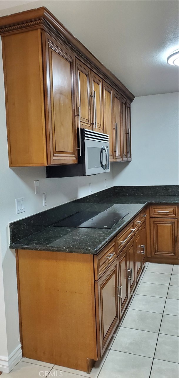 Kitchen with stainless steel microwave and induction cook top