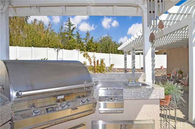 BBQ/Outdoor Kitchen with High-End BBQ/Smoker, Two Burner Cooktop, Sink, Stainless Steel Cabinetry, and Ceiling Fan