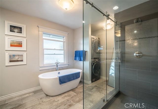 Upstairs bath tub with window view to the washer and dryer closet..