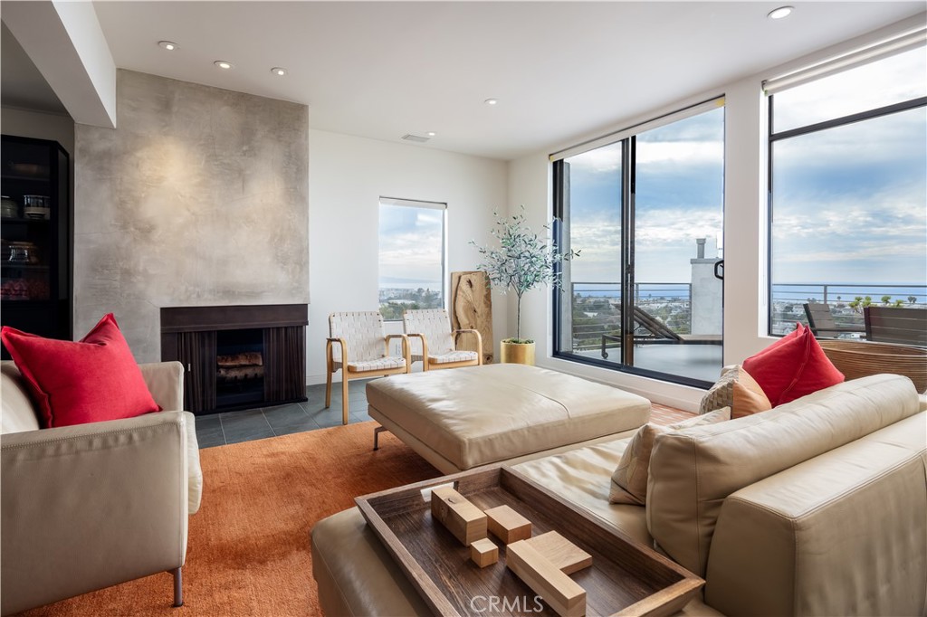 There is nothing like this in the South Bay. Exceptional 180 degree ocean views from Catalina to Malibu is what makes this top level, southwest corner Hermosa Beach property so special. Tastefully updated throughout, this home provides the enjoyment of coastal living with a touch of modern excellence, along with unobstructed views from every room! These views are completely protected from anyone building up and blocking as it sits up above current height limits. From the entrance you are welcomed by a large front patio which leads into the entryway equipped with a walk-in storage closet and additional coat closet. The fully remodeled kitchen features Caesarstone countertops, custom soft touch cabinetry, Miele double ovens, a Bertazzoni range, as well as a walk-in pantry with customizable shelves. Adjacent to the kitchen is a bonus space ideal for an at-home office with architectural plans to allow for an easy addition of a bathroom. The dining and living space flow perfectly together and are adorned with beautiful built-in wood cabinetry, walnut bookshelves and a warming fireplace. Step out onto the spacious balcony just off of the living room for those ocean breezes and gorgeous Southern California sunsets. The upper level features a guest bedroom with two extra large closets and a fully remodeled hall bath with Ann Sacks tile and Caesarstone countertops. As you step into the primary suite you are greeted with ocean views which can be enjoyed from the private balcony. The walk-in closet has been thoughtfully organized to include walnut shelving and drawers and the primary bath features Ann Sacks tile, a Toto toilet, walk-in glass shower and ample vanity space.  Additional upgrades include new plumbing throughout, solar shades and new 1 3/4" solid doors and hardware. Enjoy living just 1/2 mile to the beach in this well-maintained complex with amenities such as a solar heated pool, spa, rec room with two showers, two-car covered garage parking included with this unit, along with ample guest parking. Must be seen in person to be truly appreciated.