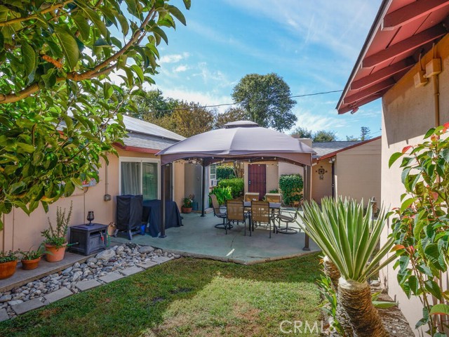 Rear patio, yard, guest home and partial view of detached 2 car garage