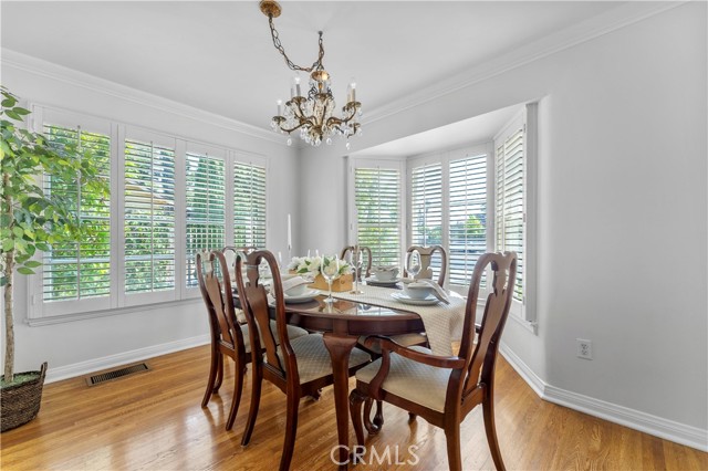 Formal dining with windows facing front yard and large window faces the tree lined driveway.