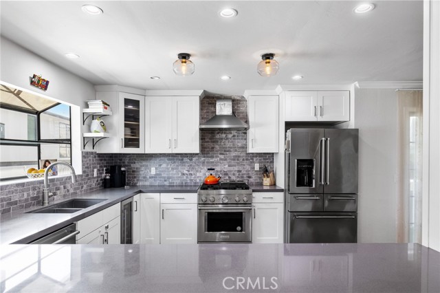 Stunning kitchen. Remodeled in 2016 with quartz countertops, KitchenAid dishwasher, KitchenAid range, KitchenAid refrigerator, and beverage cooler.