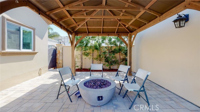 large covered patio with firepit, between the garage and the ADU