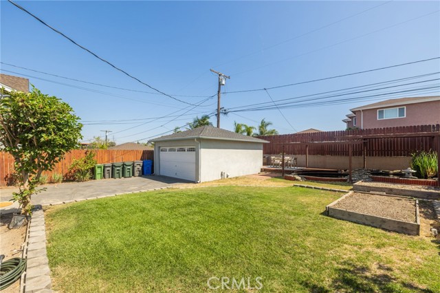 Backyard with view of garage, koi pond, fountain and refinished patio deck. There are even vegetable gardens ready for you to enjoy your own home grown vegetables.