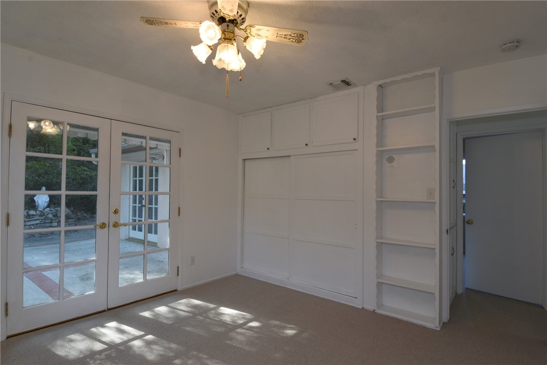 Bedroom #1 with French doors opening to the rear yard/ patio.