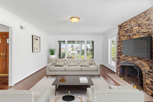Primary entertaining room features a cozy fireplace. Photo has been virtually staged.