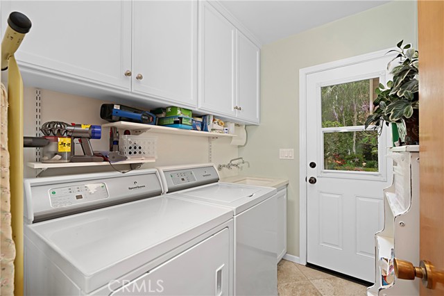 The laundry room is spacious with plenty of storage and a door to the back patio