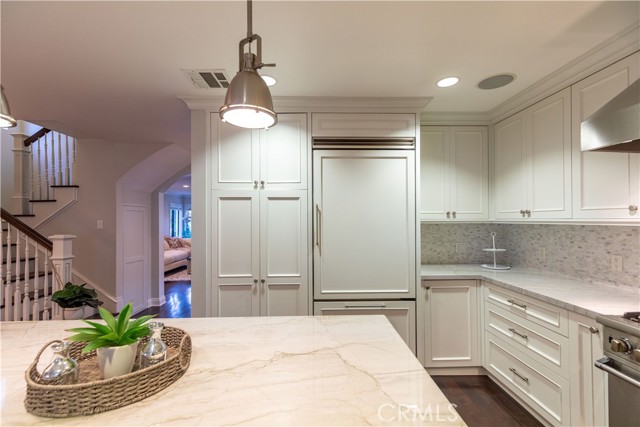 Gorgeous kitchen with nice cabinetry, Quartzite counters, and tile backsplash