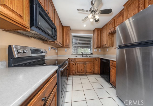 Kitchen with Ceiling Fan, Tile Flooring, Black Appliances & Stainless Refridge